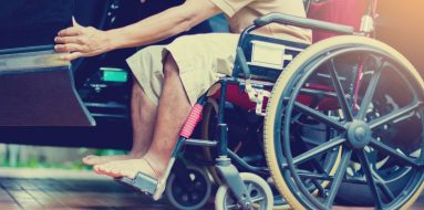 Man on a wheelchair is opening black car door — Disability Support Services in Coffs Harbour, NSW