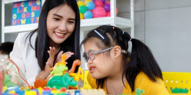 Asian Girl With Down Syndrome With Her Teacher — Disability Support Services in Coffs Harbour, NSW