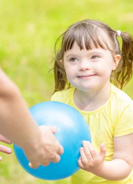 Little Girl With Down Syndrome Playing With Her Mom In The Park — Disability Support Services in Robina, QLD