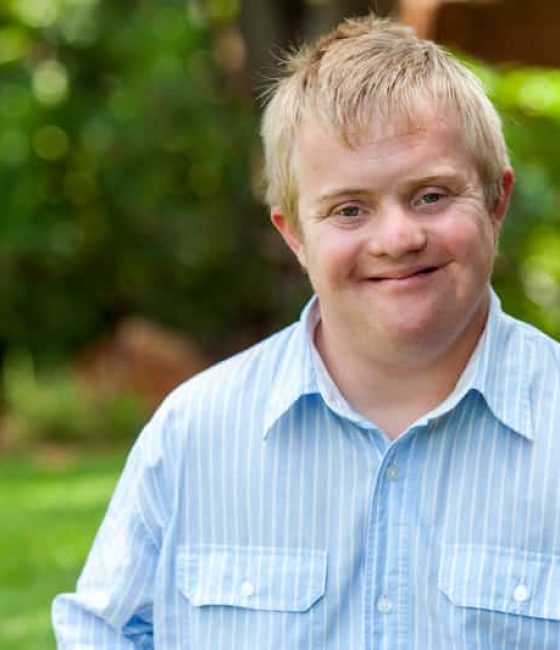 Child on blue polo smiling — Disability Support Services in Robina, QLD