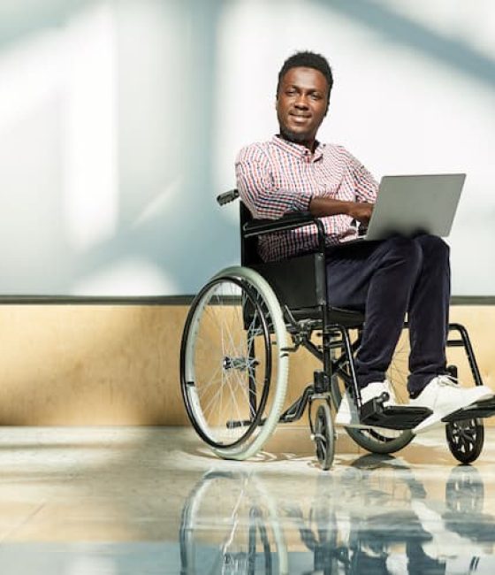 Man In Wheelchair Using Laptop — Disability Support Services in Robina, QLD