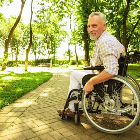Old man on wheelchair smiling — Disability Support Services in Robina, QLD